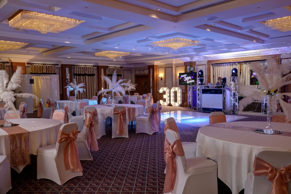 A picture of the Ayesford room at Manor Hotel Solihull nicely decorated for a birthday with an illuminated 30 on stage